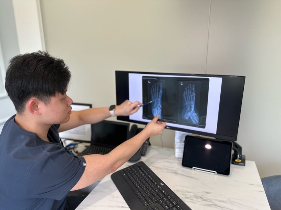 podiatrist reviewing patient's x-ray for their foot pain treatment
