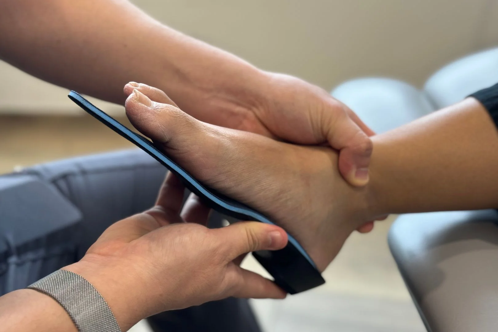 Podiatrist fitting a pair of custom flat foot insoles