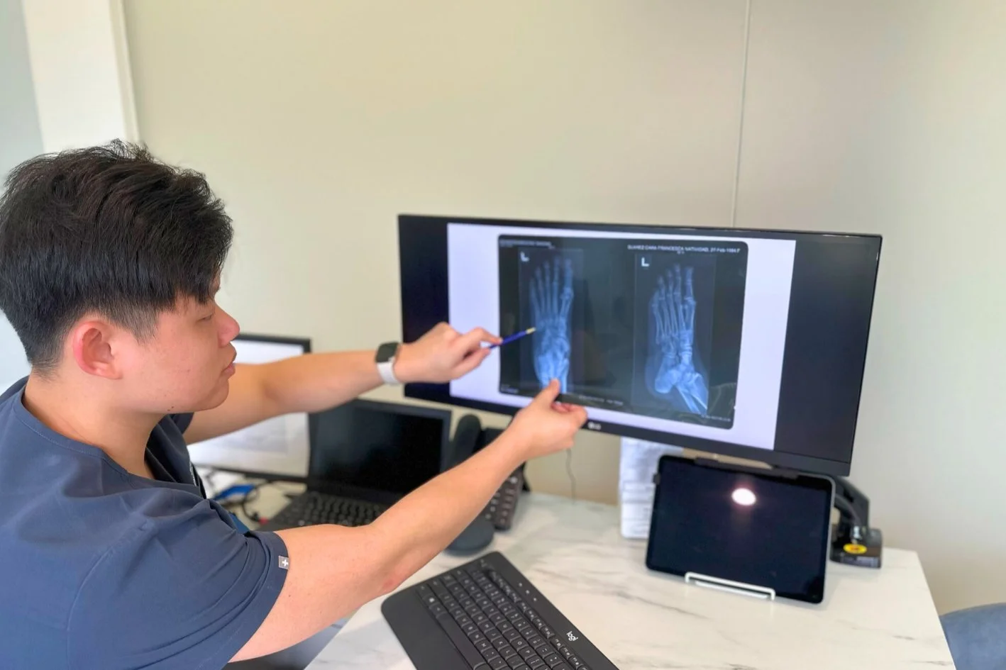 Podiatrist examining a foot x-ray in a podiatry clinic in Singapore