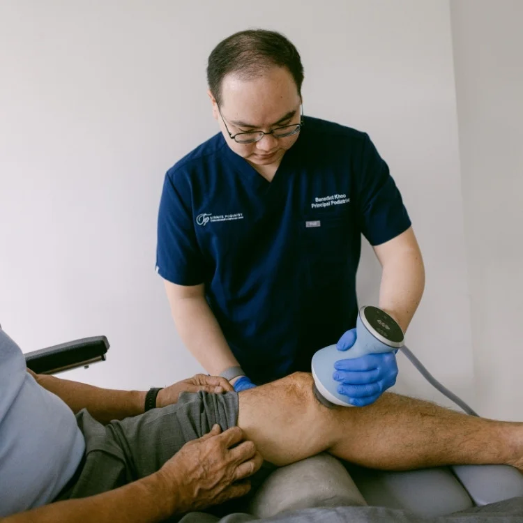 podiatrist treating knee arthritis with shockwave therapy
