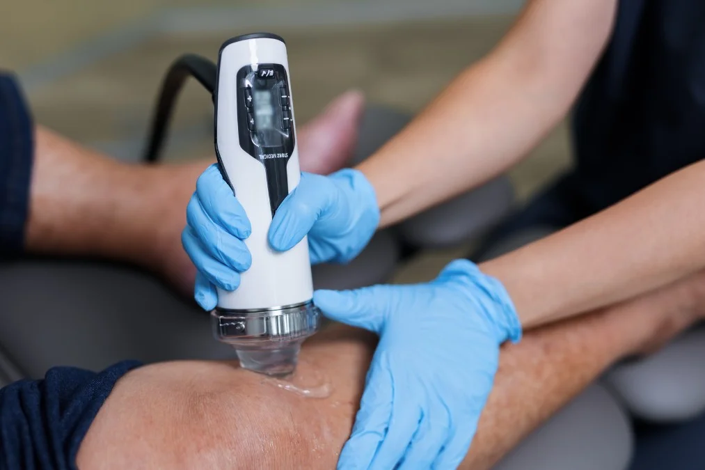 Podiatrist in Singapore performing focal extracorporeal shockwave therapy on patient with knee pain