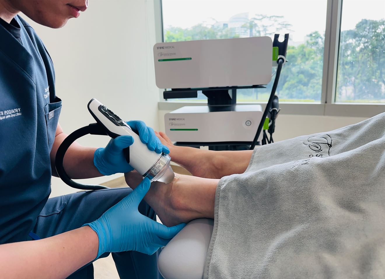 podiatrists performing shockwave therapy for ankle sprain patient