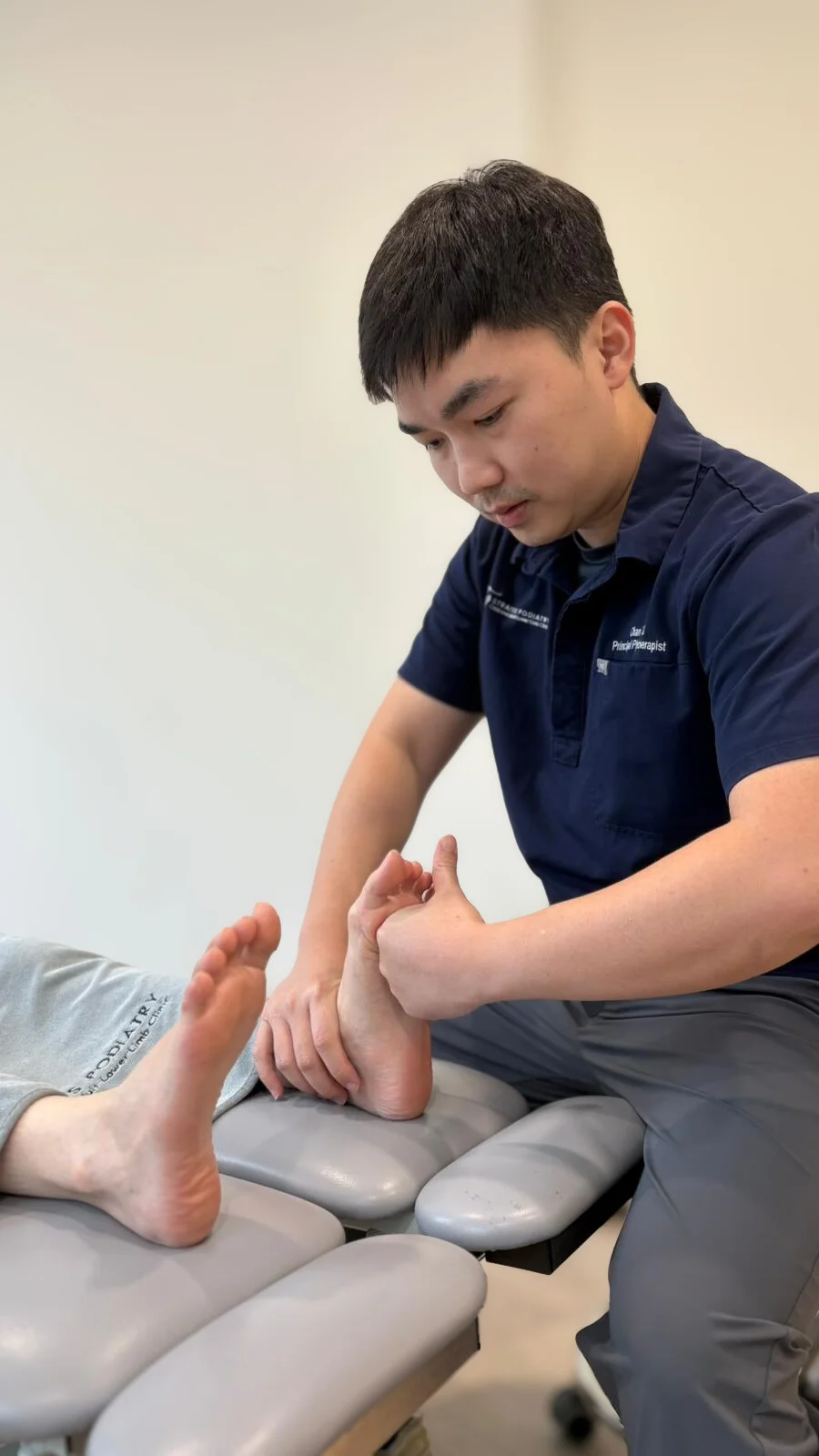 physiotherapist doing assessment on lower limb patient foot
