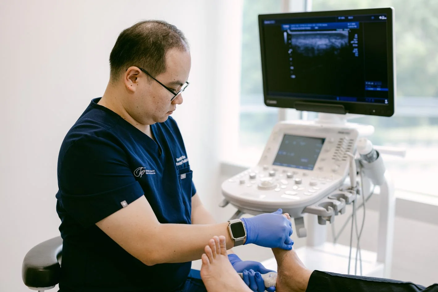podiatrist in Singapore assessing heel pain using diagnostic ultrasound