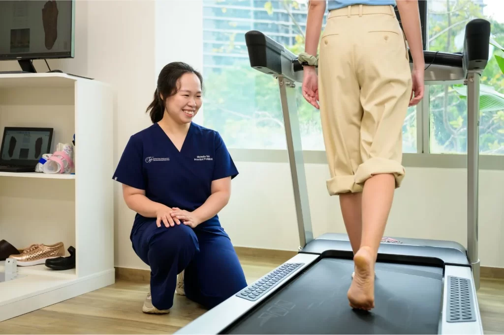 podiatrist in Singapore observing the gait pattern of a lady on a treadmill