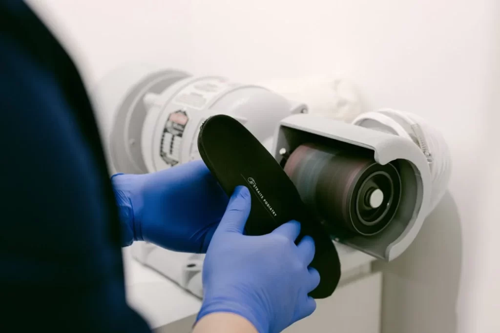 Podiatrist in Singapore shaping a custom insole