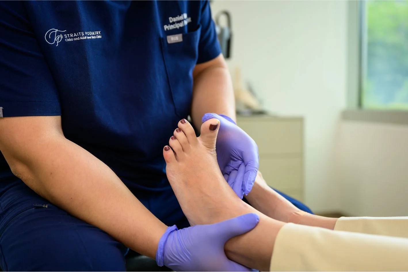 podiatrist assessing patient's foot for extensor tendonitis